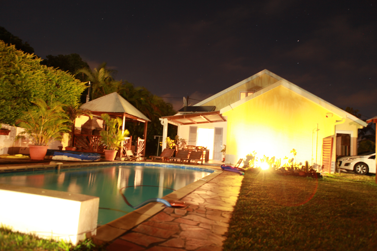 la piscine et la façade de la villa de nuit